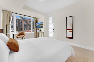 ein weißes Schlafzimmer mit einem großen Bett und einem Schreibtisch in der Unterkunft Bright & Stylish Modern Townhome in Oakville! in Oakville