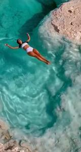 a woman is swimming in the water at Eden Luxury Villa in Ban Nong Pla Lai
