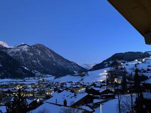 a town covered in snow with mountains in the background at Apartment Sparenmoos - OG - DG Nord-Ost by Interhome in Zweisimmen