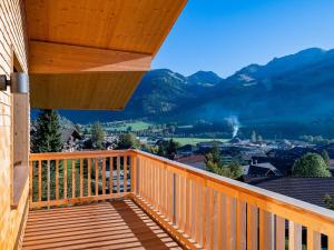 a wooden balcony with a view of mountains at Apartment Sparenmoos - OG - DG Nord-Ost by Interhome in Zweisimmen