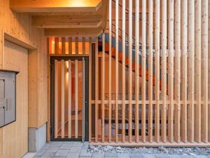 a wooden wall with a door in front of a building at Apartment Sparenmoos - OG - DG Nord-Ost by Interhome in Zweisimmen +10 photos