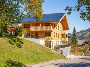 a house with a solar roof on top of a hill at Apartment Sparenmoos - OG - DG Nord-Ost by Interhome in Zweisimmen