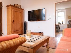 a living room with a table and a tv at Ferienwohnung am Schloss in Lemgo in Lemgo