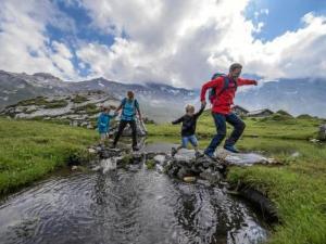 a group of three people playing in a creek at Apartment Lohnerhof AP C4 by Interhome in Adelboden
