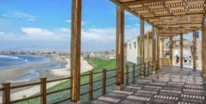 a balcony with a view of the beach and the ocean at Hotel Chicama Home and lounge in Puerto Chicama