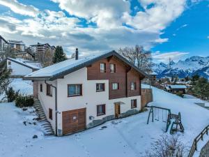 a house in the snow with mountains in the background at Holiday Home Chalet Mirabelle by Interhome in Nendaz