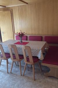une table à manger avec des chaises et un vase de fleurs. dans l'établissement Apartment Miranda by Interhome, à Saas-Almagell 10 autres photos