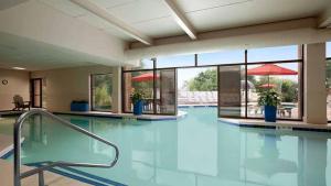 a swimming pool with blue water in a building at Woodcliff Hotel and Spa in Fairport