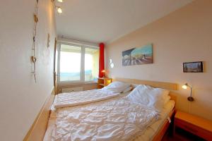 une chambre avec un lit blanc avec une fenêtre dans l'établissement Apartment Süd-Panorama mit Pool & Sauna, à Hohegeiss