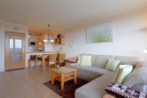 un salon avec un canapé et une table dans l'établissement Apartment Süd-Panorama mit Pool & Sauna, à Hohegeiss