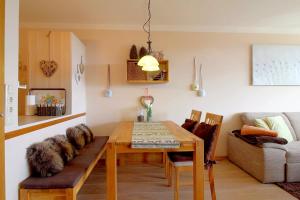 un salon avec une table et un canapé dans l'établissement Apartment Süd-Panorama mit Pool & Sauna, à Hohegeiss 3 autres photos