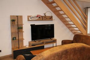 a living room with a flat screen tv on a stand at Appart Côte d'Opale in Condette