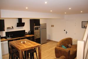 a kitchen and living room with a table and a chair at Appart Côte d'Opale in Condette +20 photos