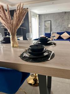 a dining room table with plates and wine glasses at Grand logement proche Colmar au calme parking wifi in Wintzenheim