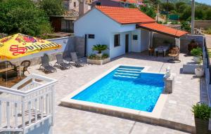 a swimming pool with an umbrella and a house at 3 Bedroom Amazing Home In Vinovac in Kruševo +26 photos