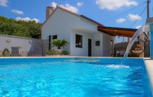 a swimming pool with a water fall in front of a house at 3 Bedroom Amazing Home In Vinovac in Kruševo