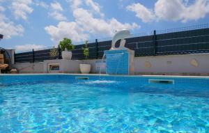 a large swimming pool with a water fountain at 3 Bedroom Amazing Home In Vinovac in Kruševo