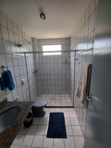 a bathroom with a toilet and a sink and a shower at Novidade na Enseada Azul! Apto com churrasqueira, área gourmet e Ar condicionado a 150m da praia in Guarapari +12 photos