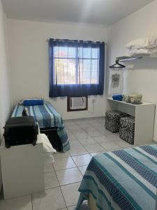 a bedroom with two beds and a bed sidx sidx sidx sidx sidx at Novidade na Enseada Azul! Apto com churrasqueira, área gourmet e Ar condicionado a 150m da praia in Guarapari
