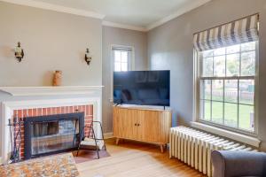 a living room with a fireplace and a flat screen tv at Walkable Thiensville Retreat Near Hiking! in Thiensville