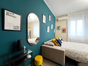 a bedroom with a blue wall and a mirror at Le Dimore del Corso in Catania