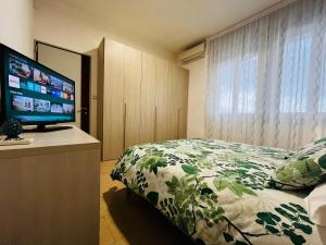 a bedroom with a bed and a flat screen tv at Le Dimore del Corso in Catania