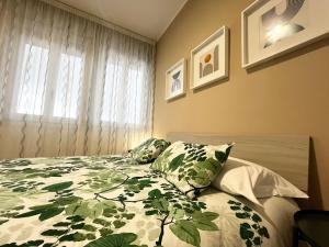 a bedroom with a bed with a green and white blanket at Le Dimore del Corso in Catania
