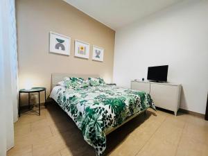 a bedroom with a bed and a flat screen tv at Le Dimore del Corso in Catania