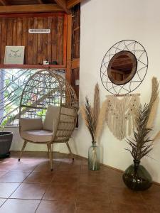 une chambre avec une chaise en rotin et deux plantes dans l'établissement La Amapola Lodge, Bungalow en Península de Osa., à Barrigones