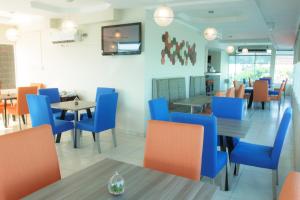 un restaurante con mesas y sillas azules y naranjas en Hotel Bahía Suites en Panamá