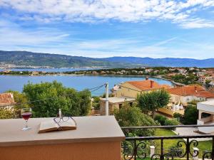 a glass of wine on a balcony with a view of a lake at Villa Rebeka in Šilo