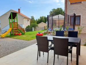 a dining room table with chairs and a playground at Villa Rebeka in Šilo