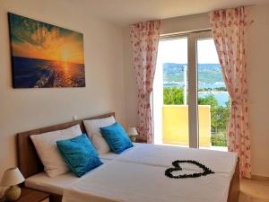 a bedroom with a bed with a large window at Villa Rebeka in Šilo