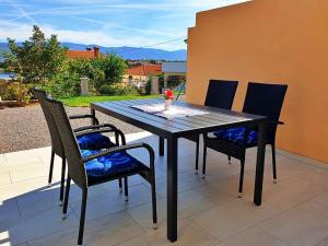 a black table and chairs on a patio at Villa Rebeka in Šilo