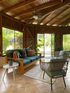 un salon avec un canapé bleu et des chaises dans l'établissement La Amapola Lodge, Bungalow en Península de Osa., à Barrigones