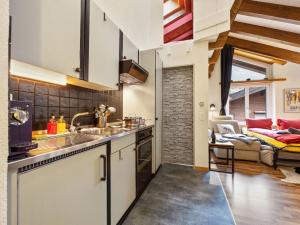 Una cocina con gabinetes blancos y una sala de estar. en Apartment Haus Bodmen B Apartment B 43 by Interhome, en Zermatt
