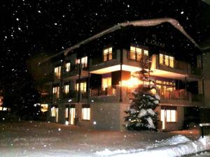 a building with a christmas tree in front of it at Apartment Alcazar by Interhome in Saas-Grund