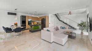 a living room with white furniture and a staircase at Villa Gabi by Villas Holiday in Donji Rukavac
