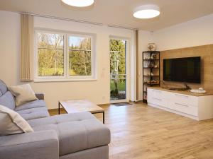 a living room with a couch and a flat screen tv at Apartment Markéta by Interhome in Smržovka