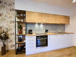 a kitchen with white cabinets and a stove at Apartment Markéta by Interhome in Smržovka