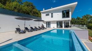 a villa with a swimming pool in front of a house at Villa Gabi by Villas Holiday in Donji Rukavac