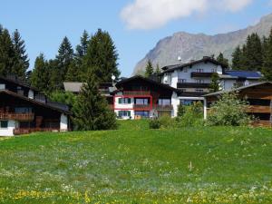 a group of buildings in a field of grass at Apartment Stgirat Bellaval by Interhome in Valbella