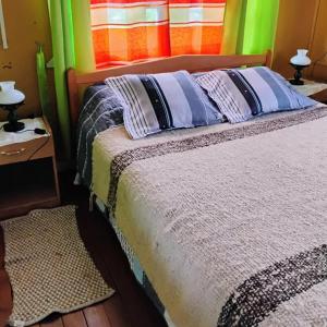1 dormitorio con 1 cama con paredes coloridas en Hospedaje Chumaihuen, en Quellón 10 fotos más