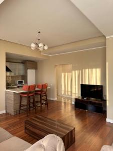 a living room with a kitchen and a table with chairs at Prime Suites in Bishkek +21 photos
