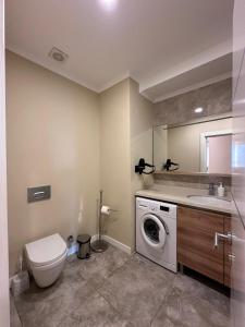 a bathroom with a washing machine and a sink at Prime Suites in Bishkek +21 photos