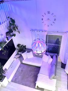 a living room with a purple couch and a clock at Hopea Villa in Vuokatti
