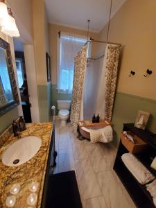 a bathroom with a shower and a sink and a tub at The Old Buggy Inn in Carthage