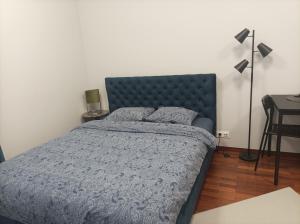 Solidarnosci155GuestRooms في وارسو: غرفة نوم بها سرير مع لحاف أزرق