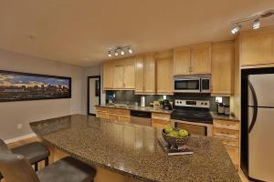 a kitchen with a large island with a bowl of fruit at Ice District 2 Kings Underground Park Patio in Edmonton