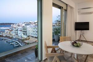 a living room with a table and a view of a harbor at Atmόsphera Ι Contemporary living in Agios Nikolaos +10 photos